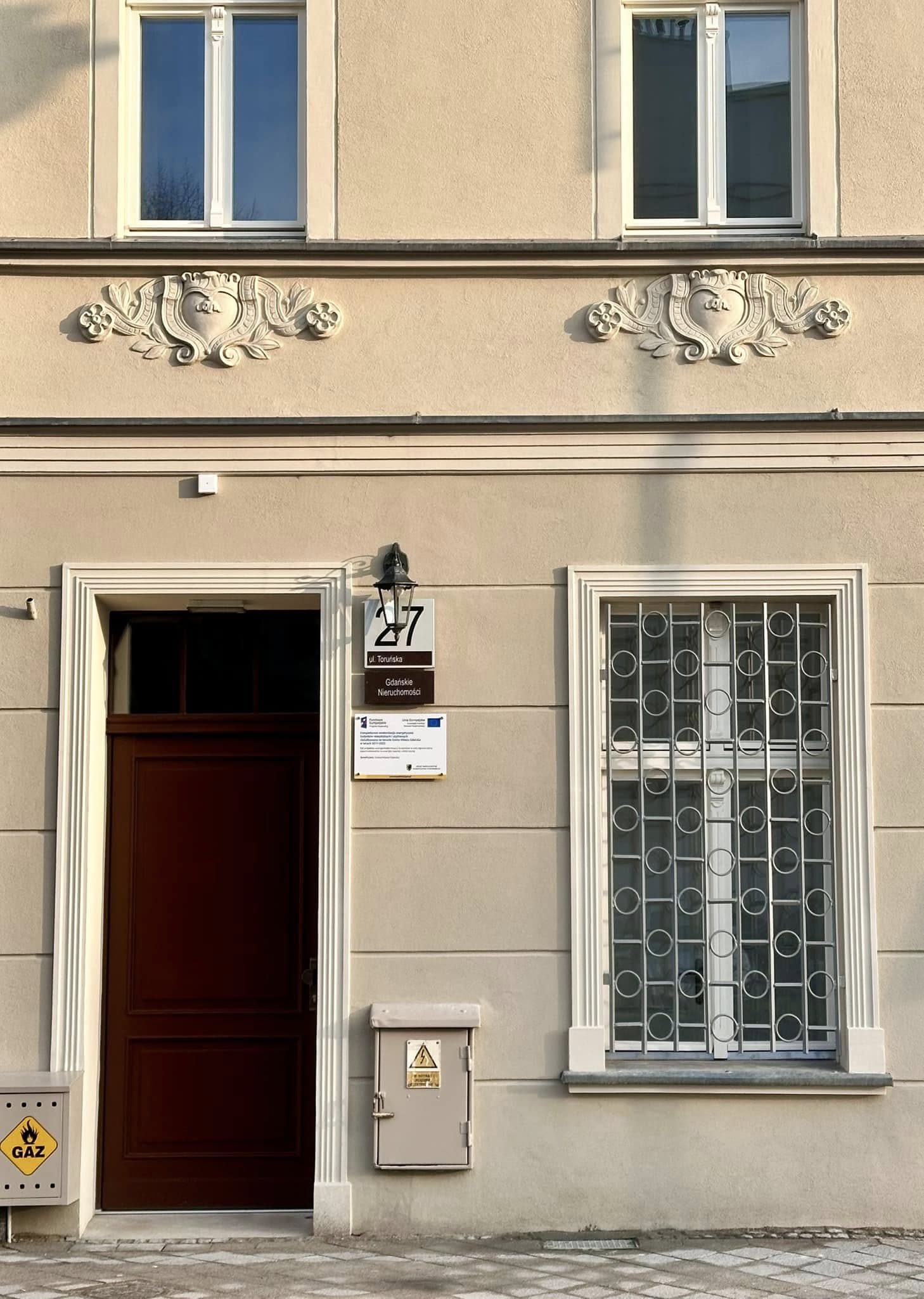 Zdjęcie przedstawia elewację budynku z tabliczką adresową