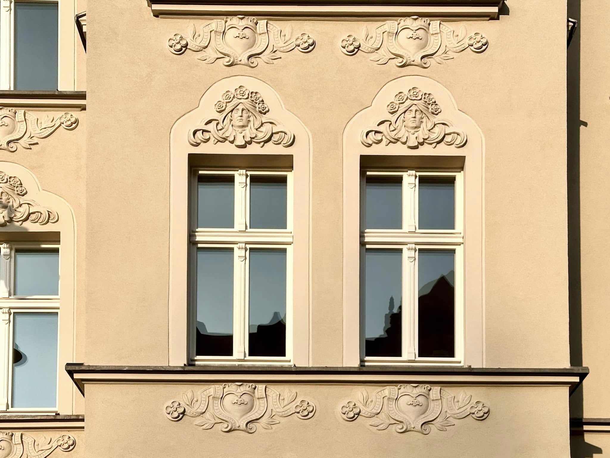 Zdjęcie przedstawia elewację budynku w kremowych barwach