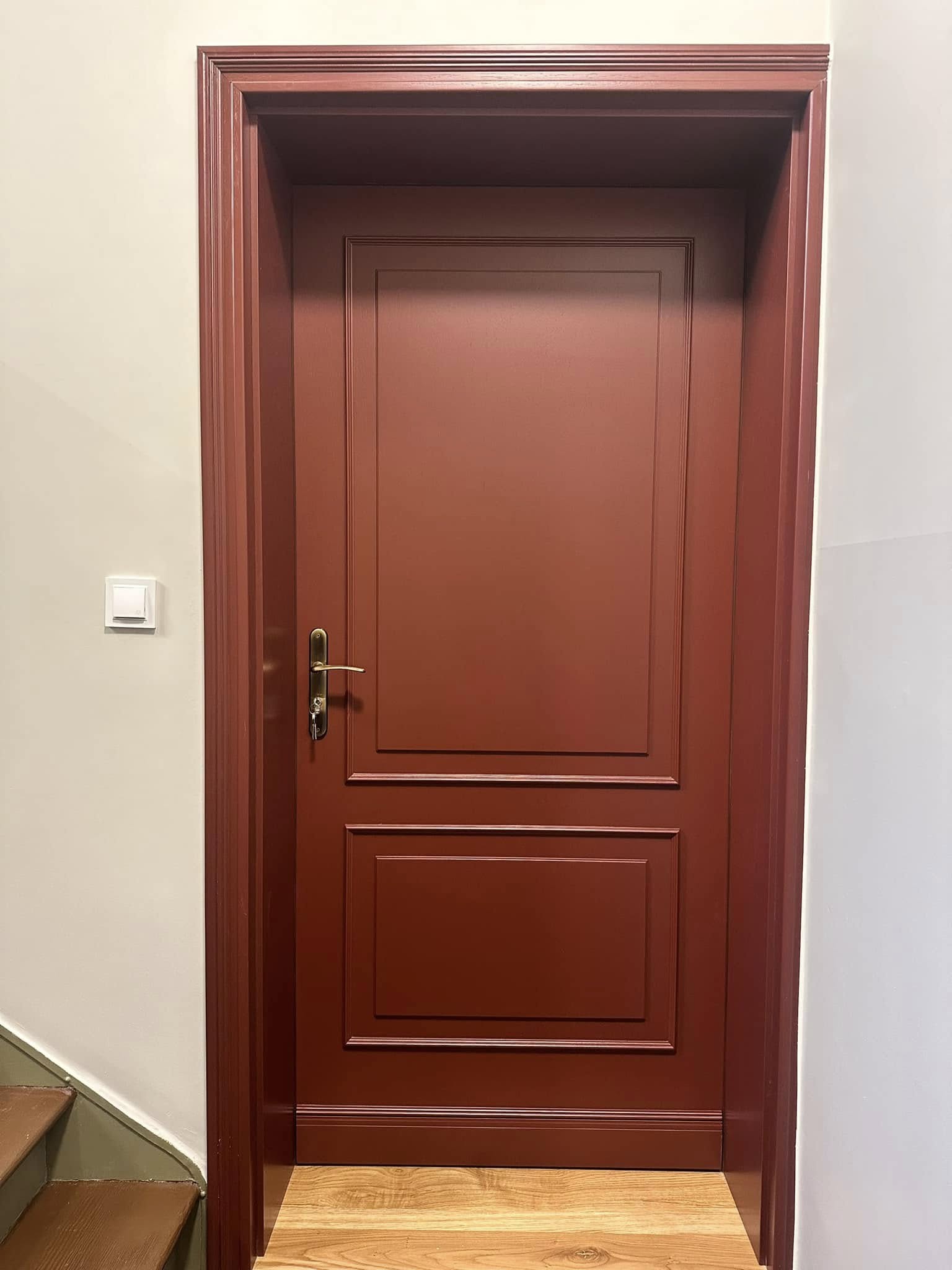 Zdjęcie przedstawia ciemnobrązowe drzwi
