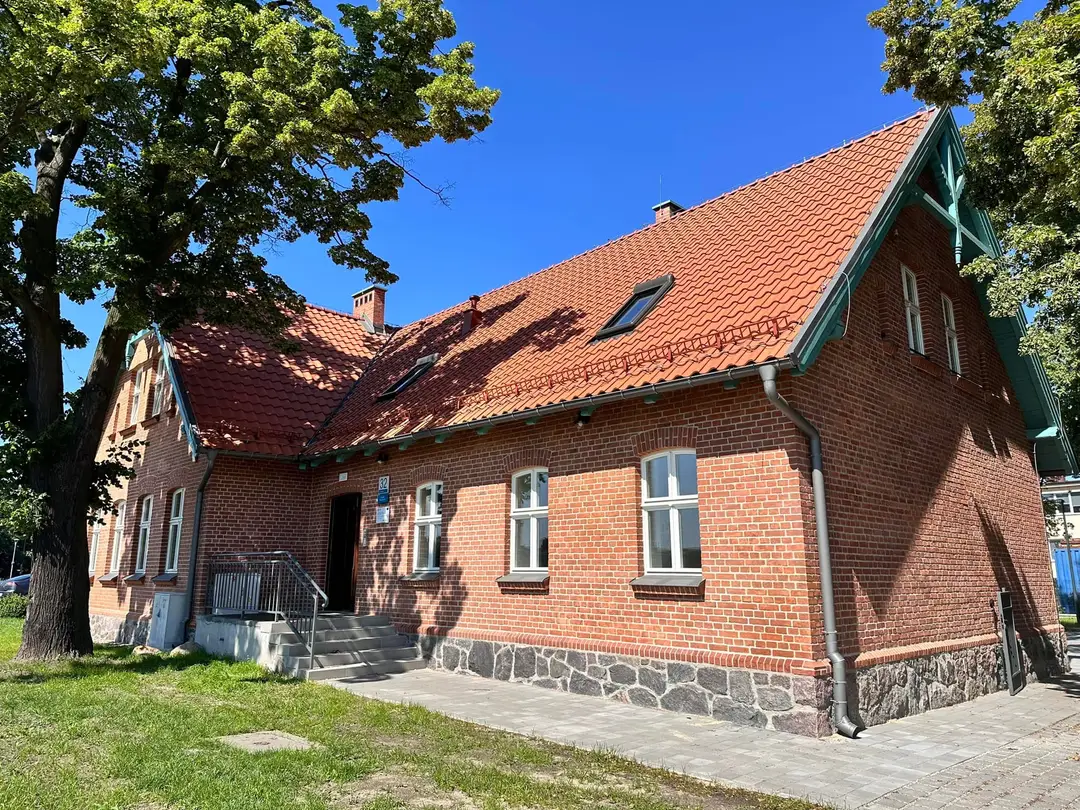 Zdjęcie przedstawia budynek po modernizacji przy ul. Gdańskiej 32 z odrestaurowaną ceglaną elewacją