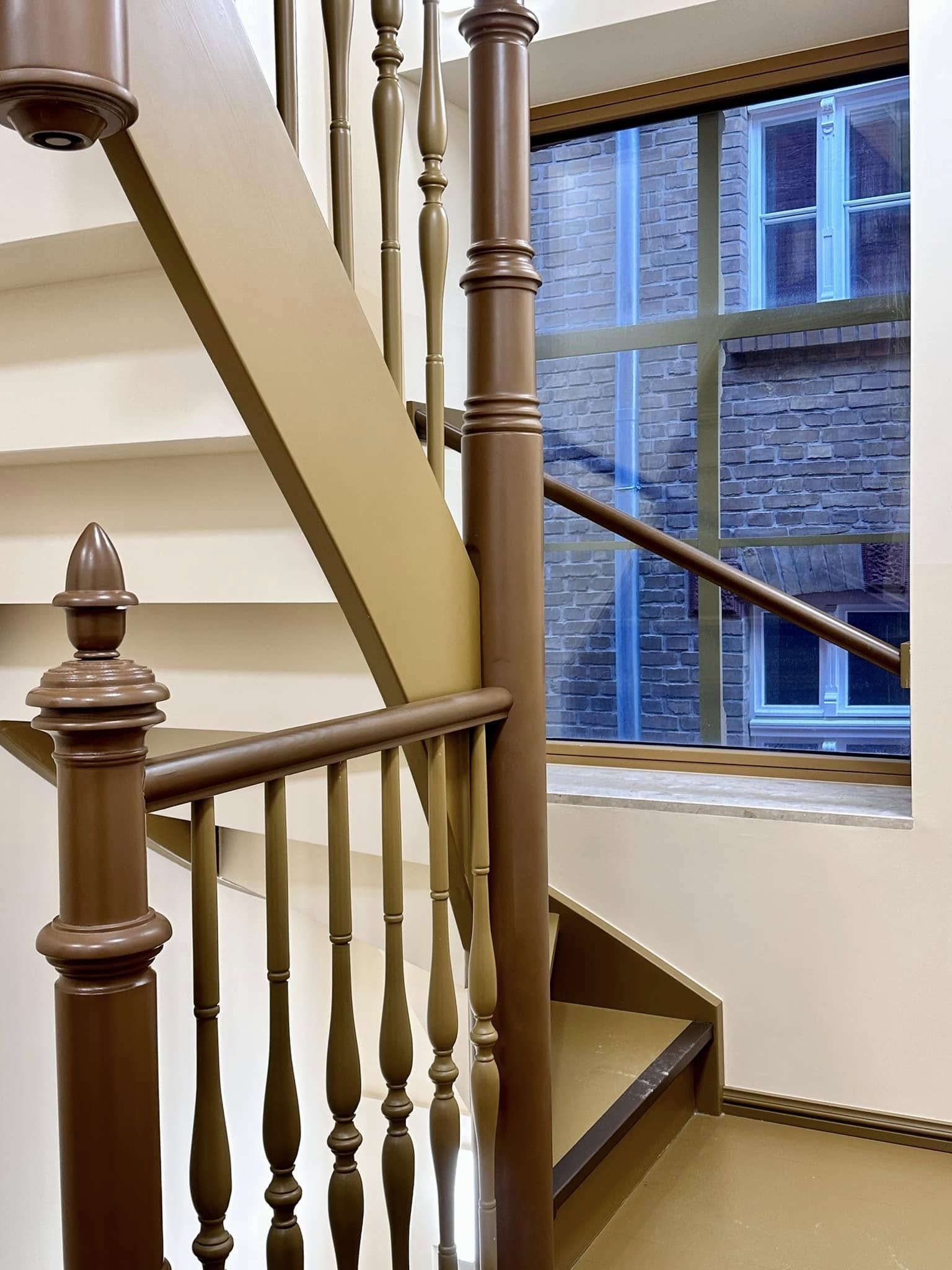 Zdjęcie przedstawia klatkę schodową w kolorze miodowym