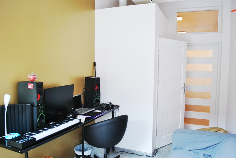 Zdjęcie przedstawia pomieszczenie Youth Point po remoncie z biurkiem na którym stoi sprzęt komputerowy i muzyczny.