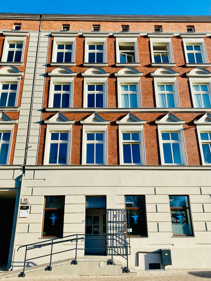 Zdjęcie przedstawia budynek przy ul. Trakt Św. Wojciecha 85 w przybliżeniu na elewacje i zdobiące ją detale.